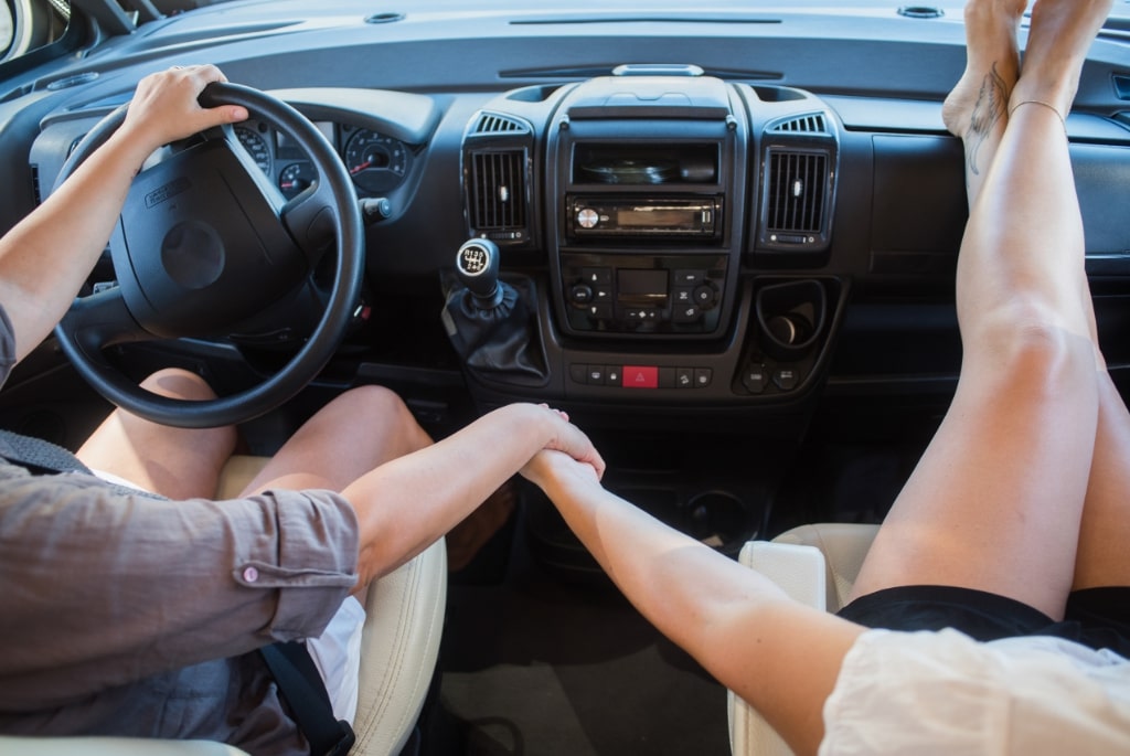 Wohnmobil mieten Paar Haendchen Haltend bei Fahrt